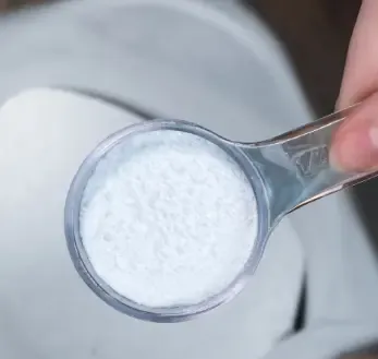 White magnesium BHB powder in a clear measuring scoop